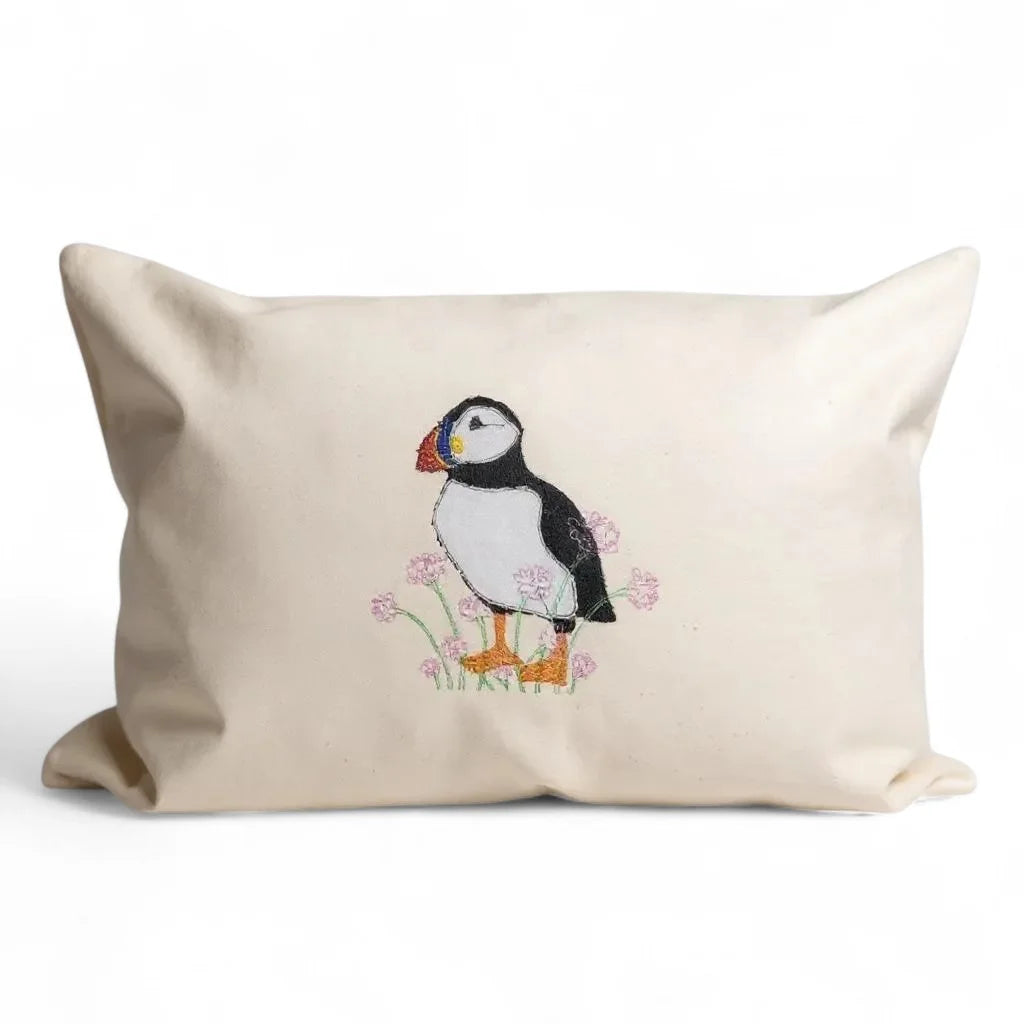 Embroidered Shetland Puffin Cushion with pink flowers.