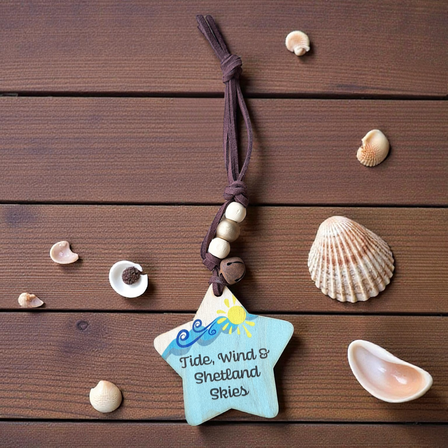 Wooden star ornament with "Tide, Wind & Shetland Skies" text and seashells.