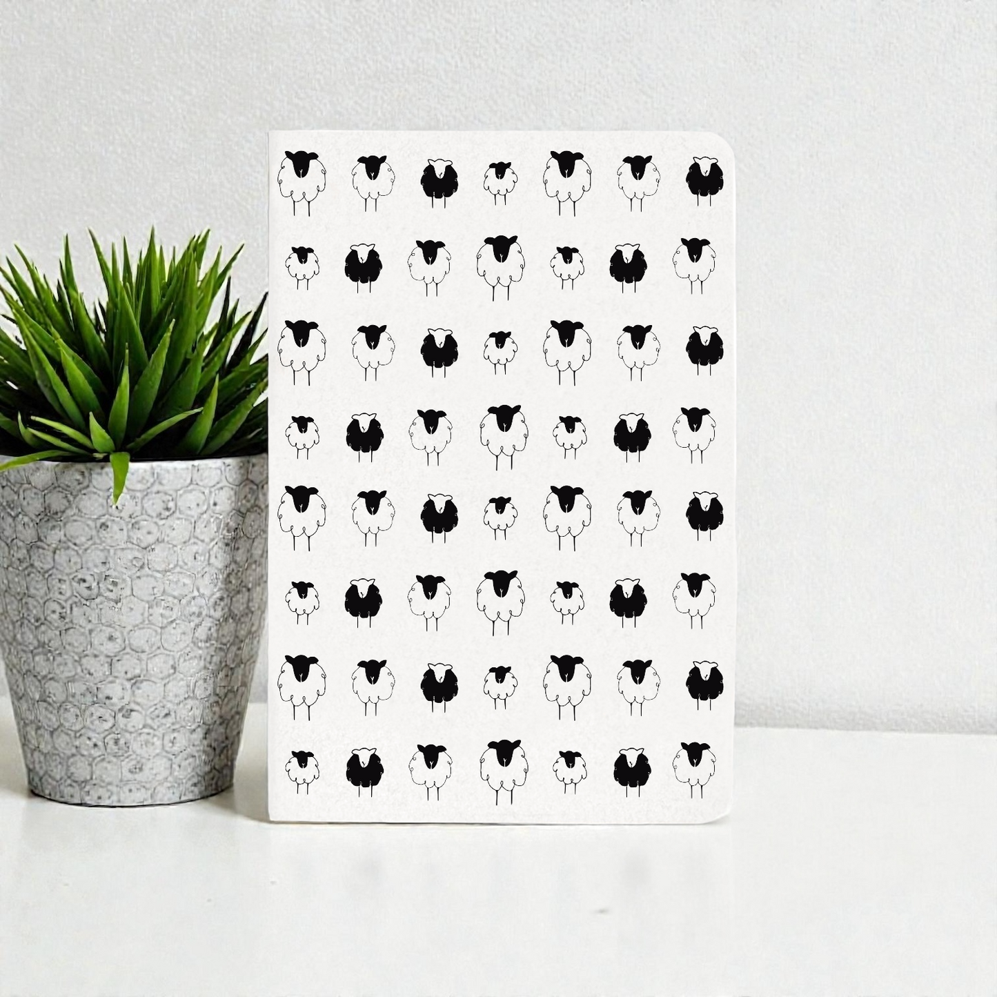 A6 pocket diary with a repeating pattern of black and white sheep.