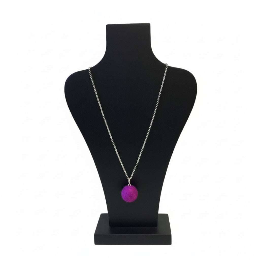 Hand felted purple wool ball pendant on a silver plated chain displayed on a black bust.