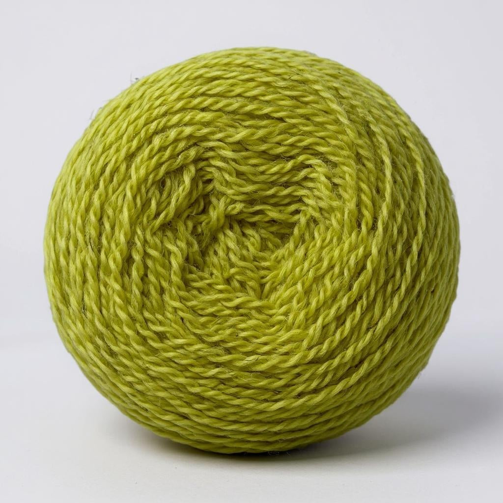 A ball of hand-dyed Shetland wool in a bright green celandine shade.