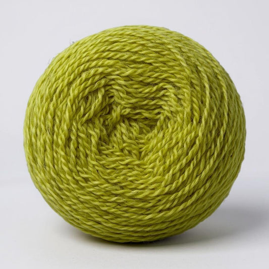 A ball of hand-dyed Shetland wool in a bright green celandine shade.