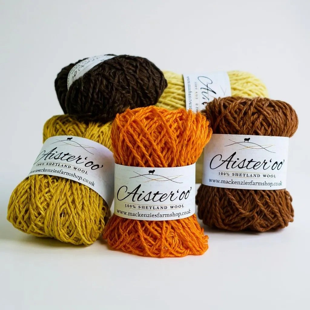 Five balls of Aister 'oo' Shetland wool in brown, yellow, and orange.