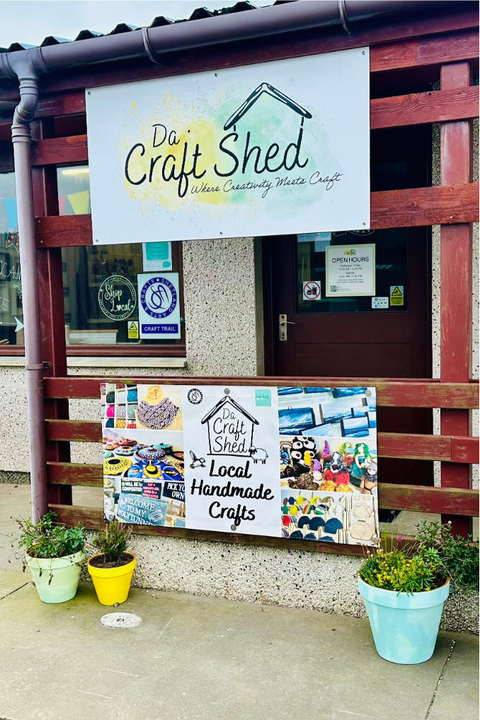 Da Craft Shed entrance with signs and plants outside
