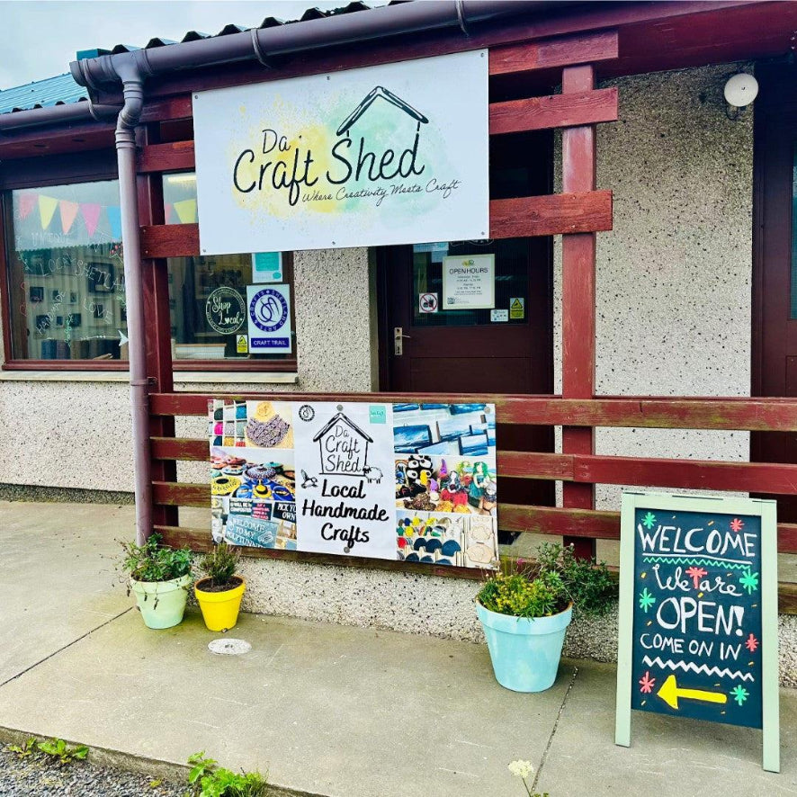 Da Craft Shed entrance with signs and potted plants