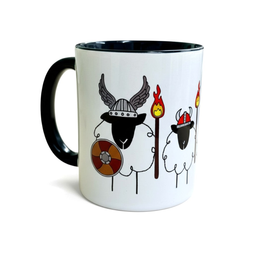 A white mug with a black handle features cartoon sheep dressed as Vikings.