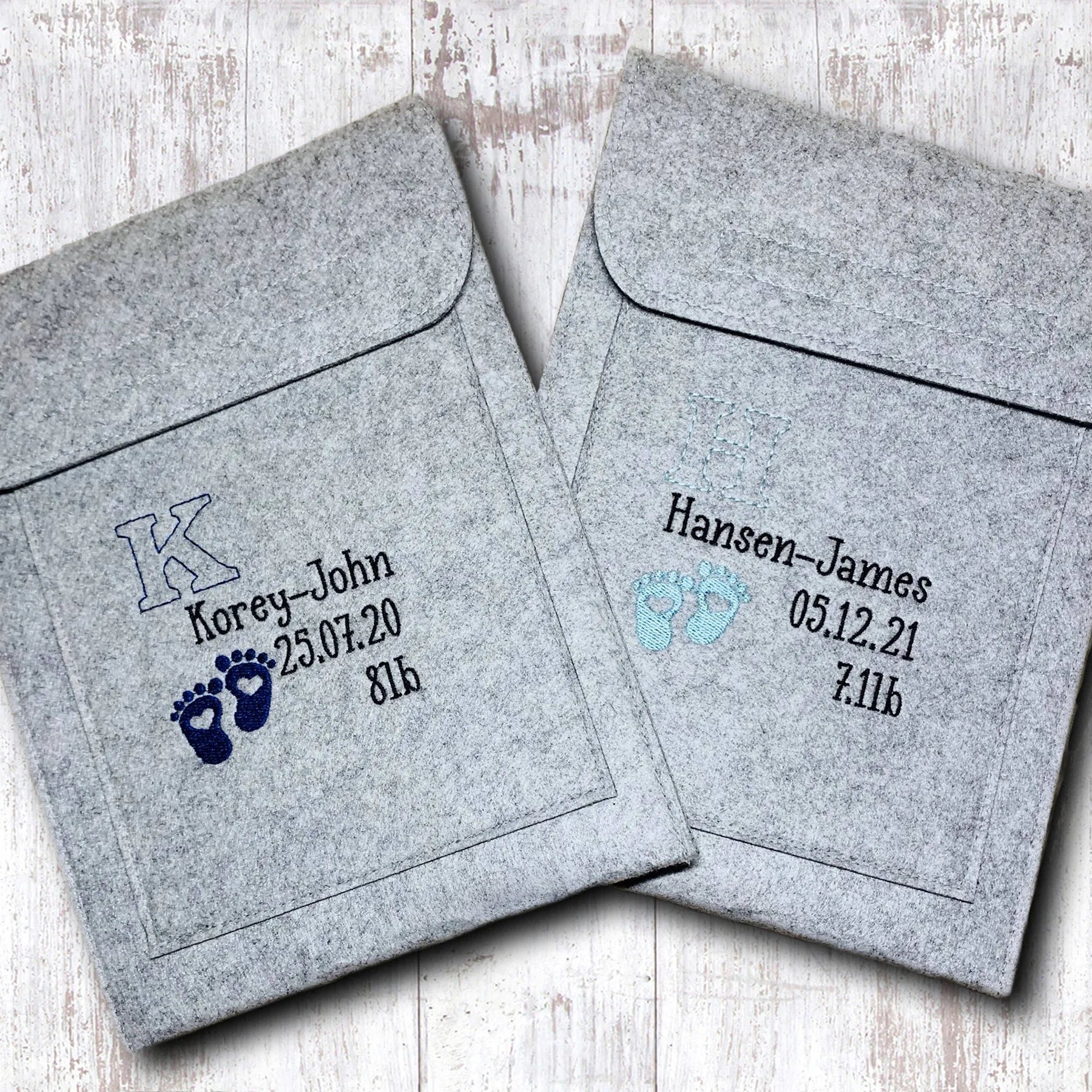 Two gray envelopes with personalized text on a light wooden surface