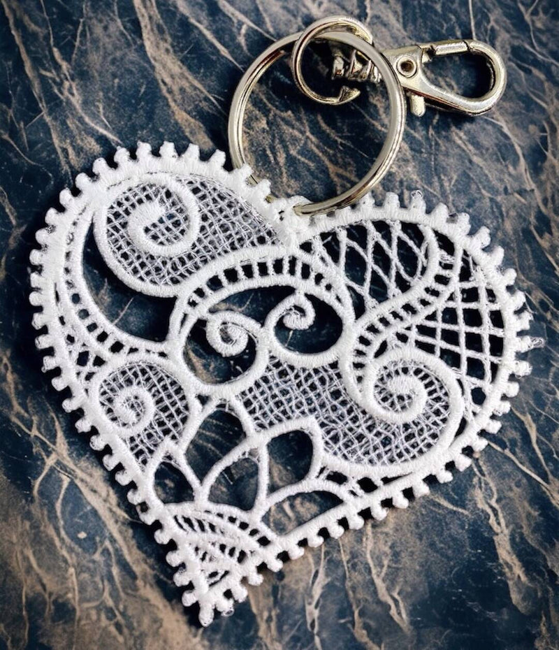 Lace heart-shaped keychain on a textured surface
