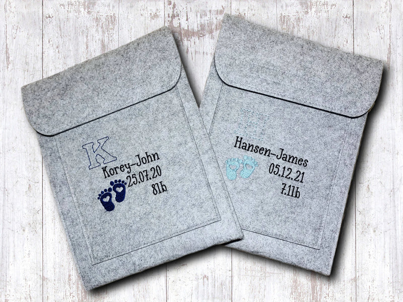 Two gray envelopes with personalised text and graphics on a light wooden surface