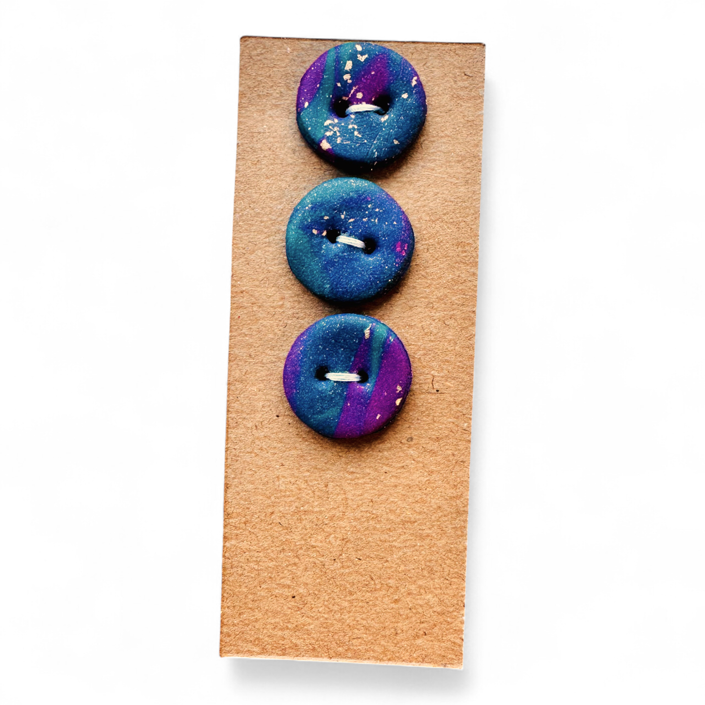 Three handmade round polymer clay buttons with gold leaf shimmer.