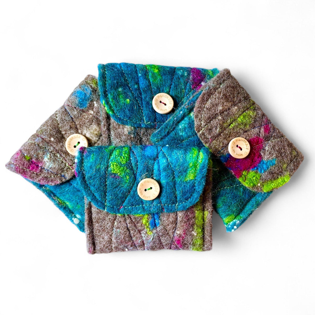 Handmade felt purses with wooden buttons, featuring colorful abstract designs.