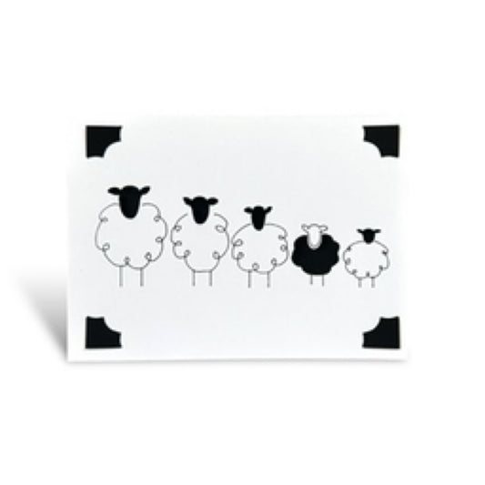 Handmade card featuring a line of sheep, one of which is black.