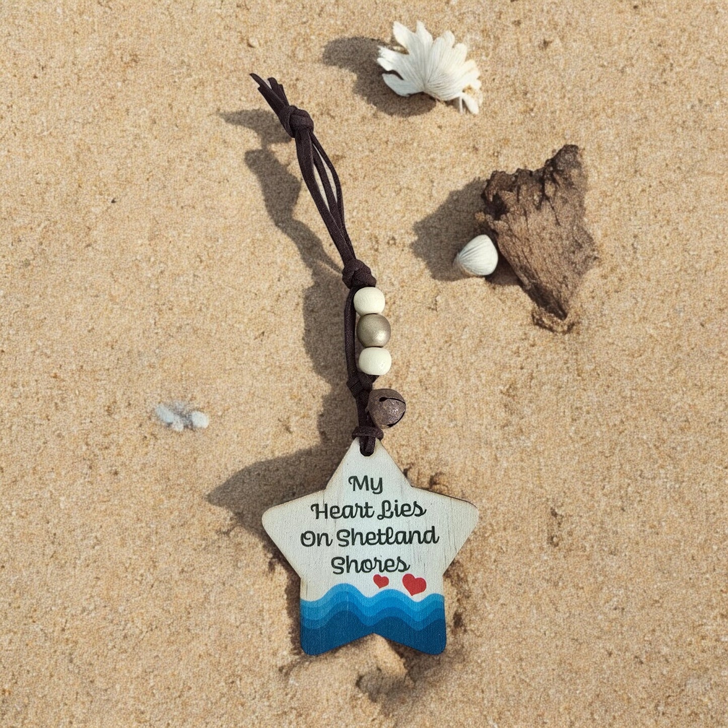 Wooden star ornament with "My Heart Lies On Shetland Shores" text and wave design.