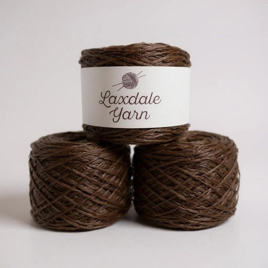 Three skeins of brown Laxdale Yarn stacked with a label.