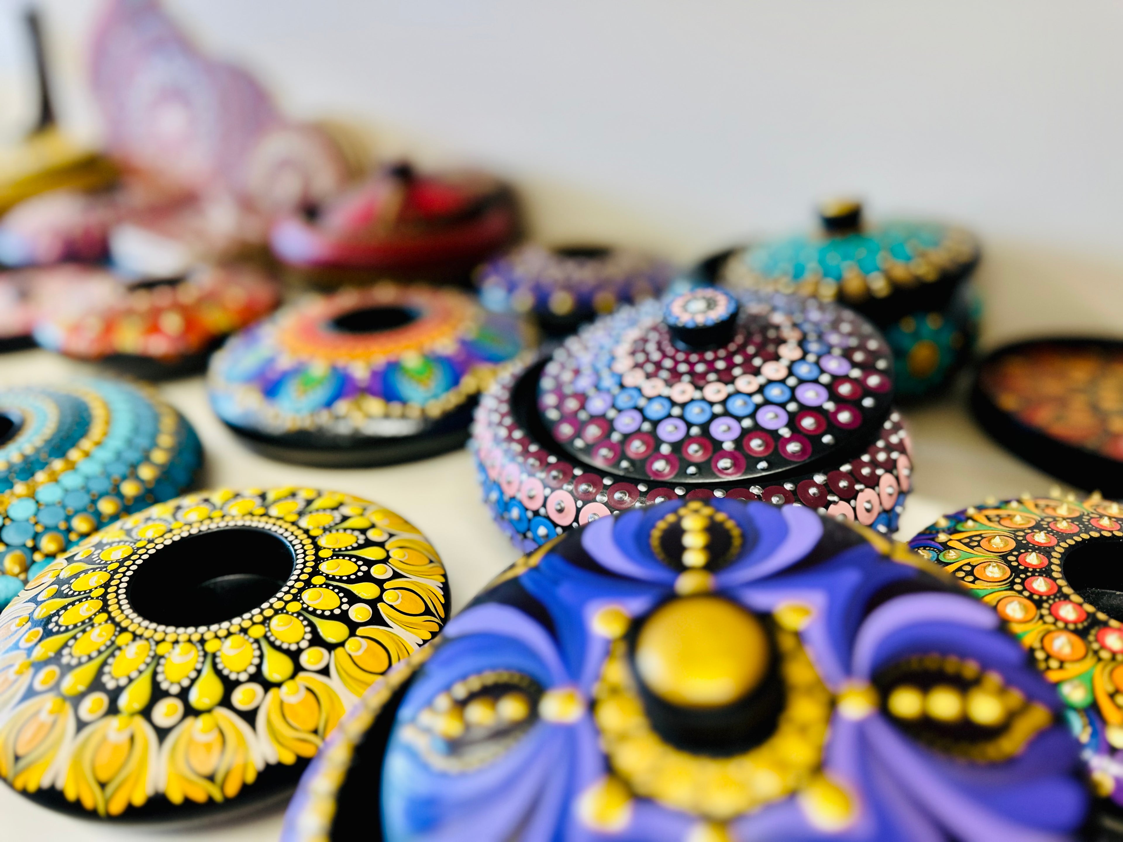 Colorful decorative lids with intricate patterns on a white background