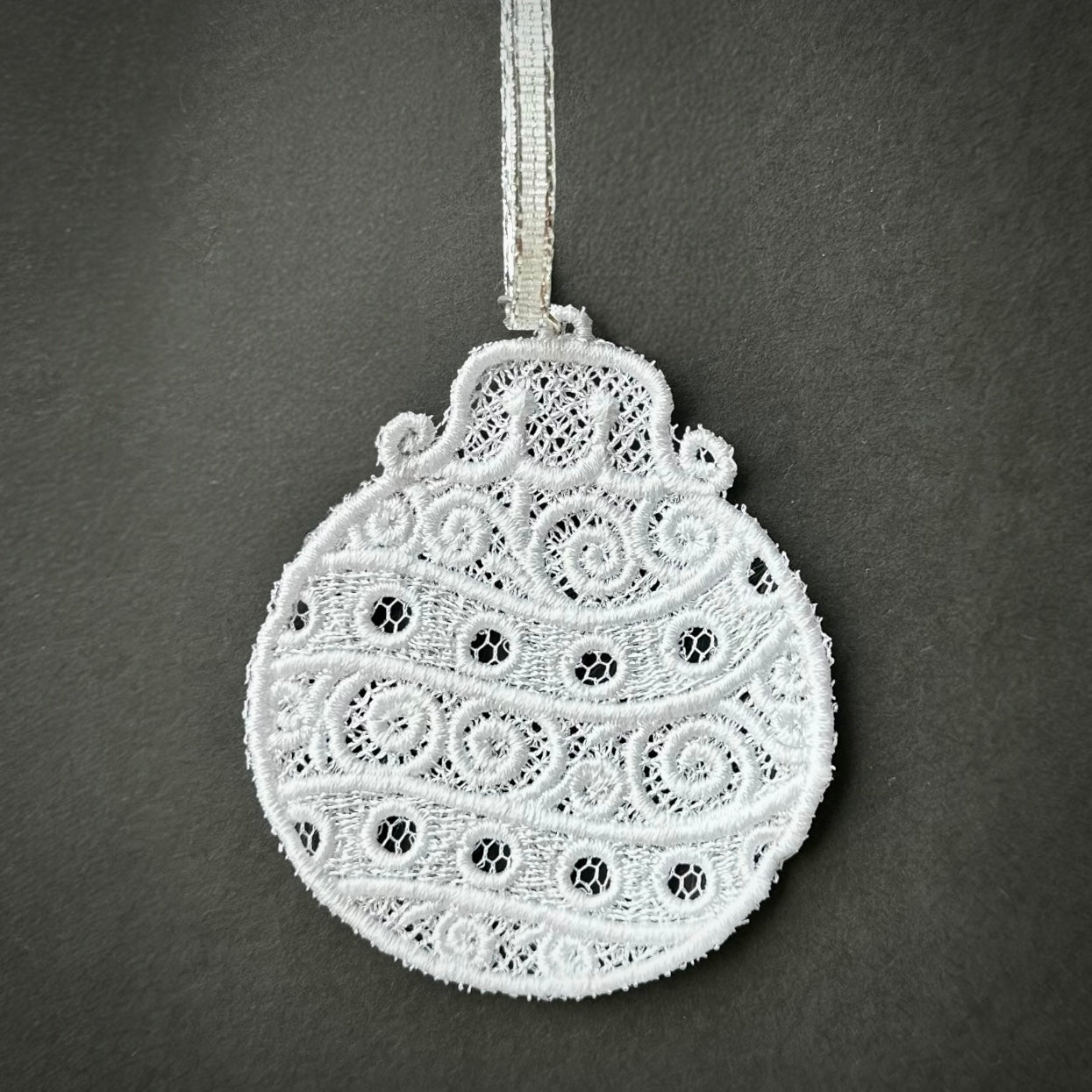 White lace Christmas ornament with a decorative pattern.