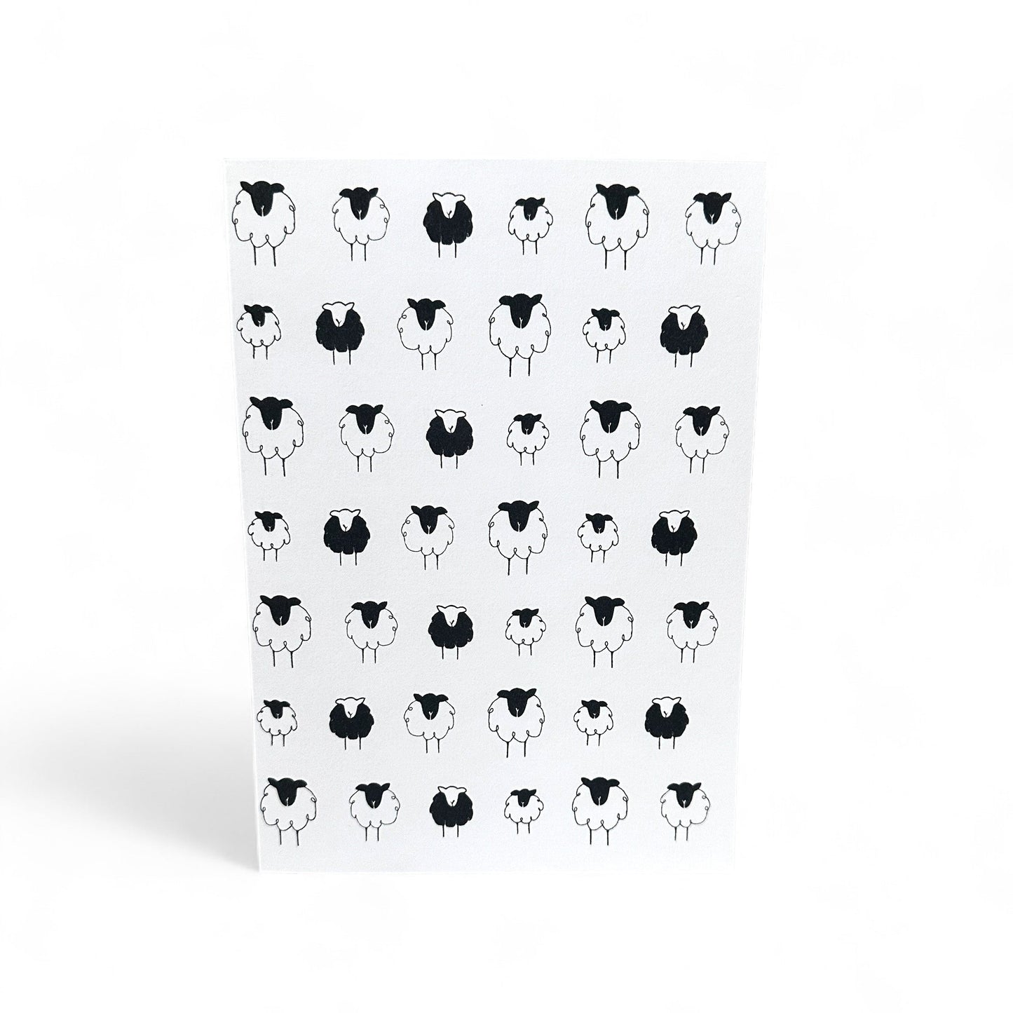 Printed card with a pattern of black and white sheep illustrations.