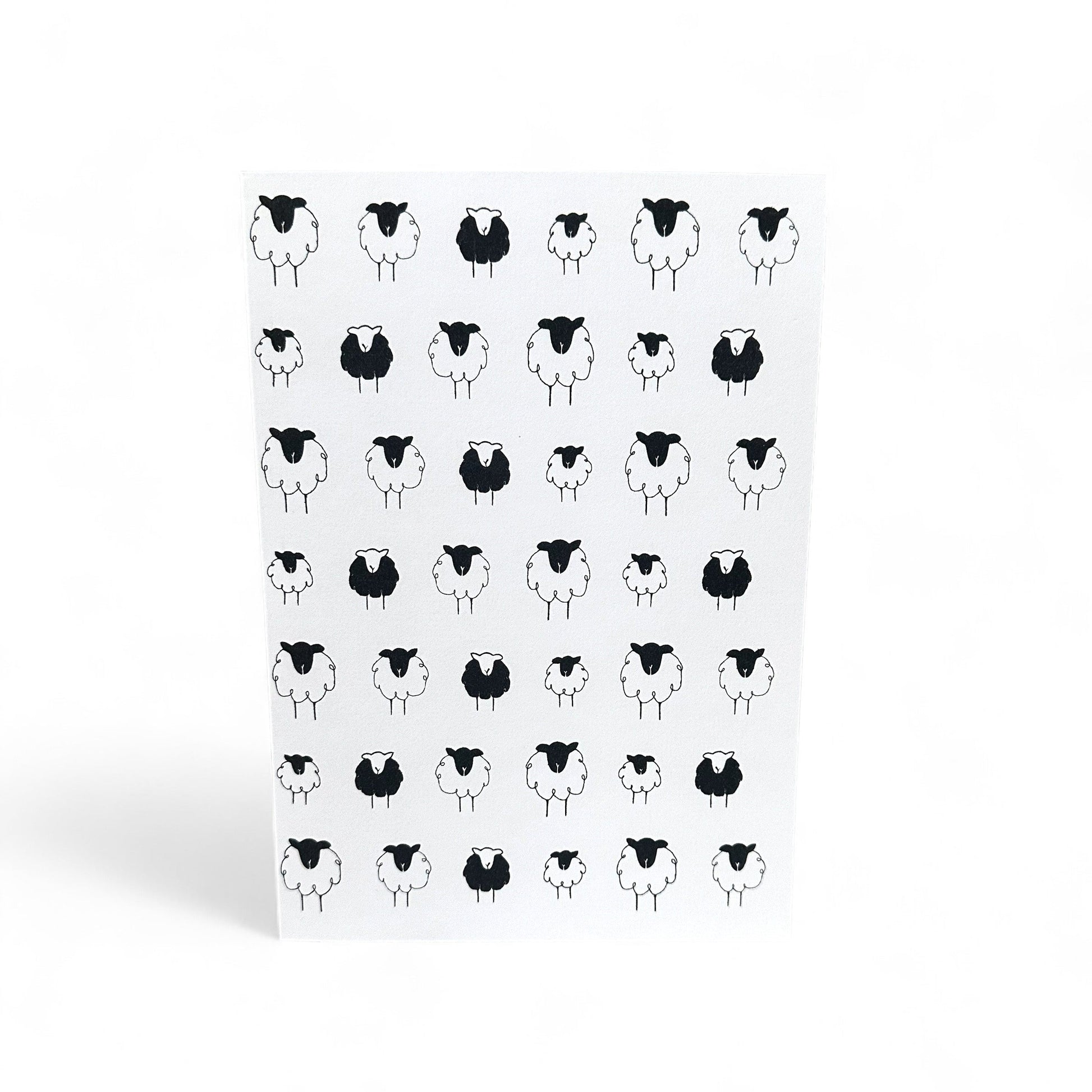 Printed card with a pattern of black and white sheep illustrations.