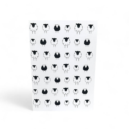 Printed card with a pattern of black and white sheep illustrations.