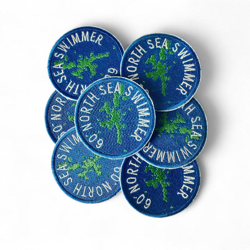 Set of blue embroidered patches with 'North Sea Swimmer' text on a white background