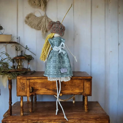 Shetland handmade macramѐ doll with yellow hair and a patterned blue dress.