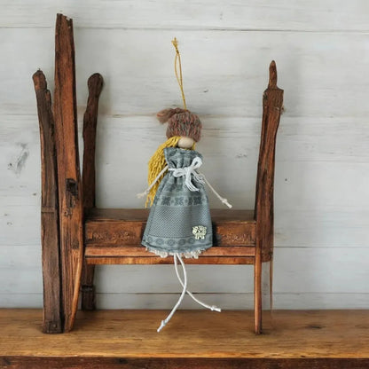 Handmade macramѐ doll with yellow hair and a grey patterned dress.