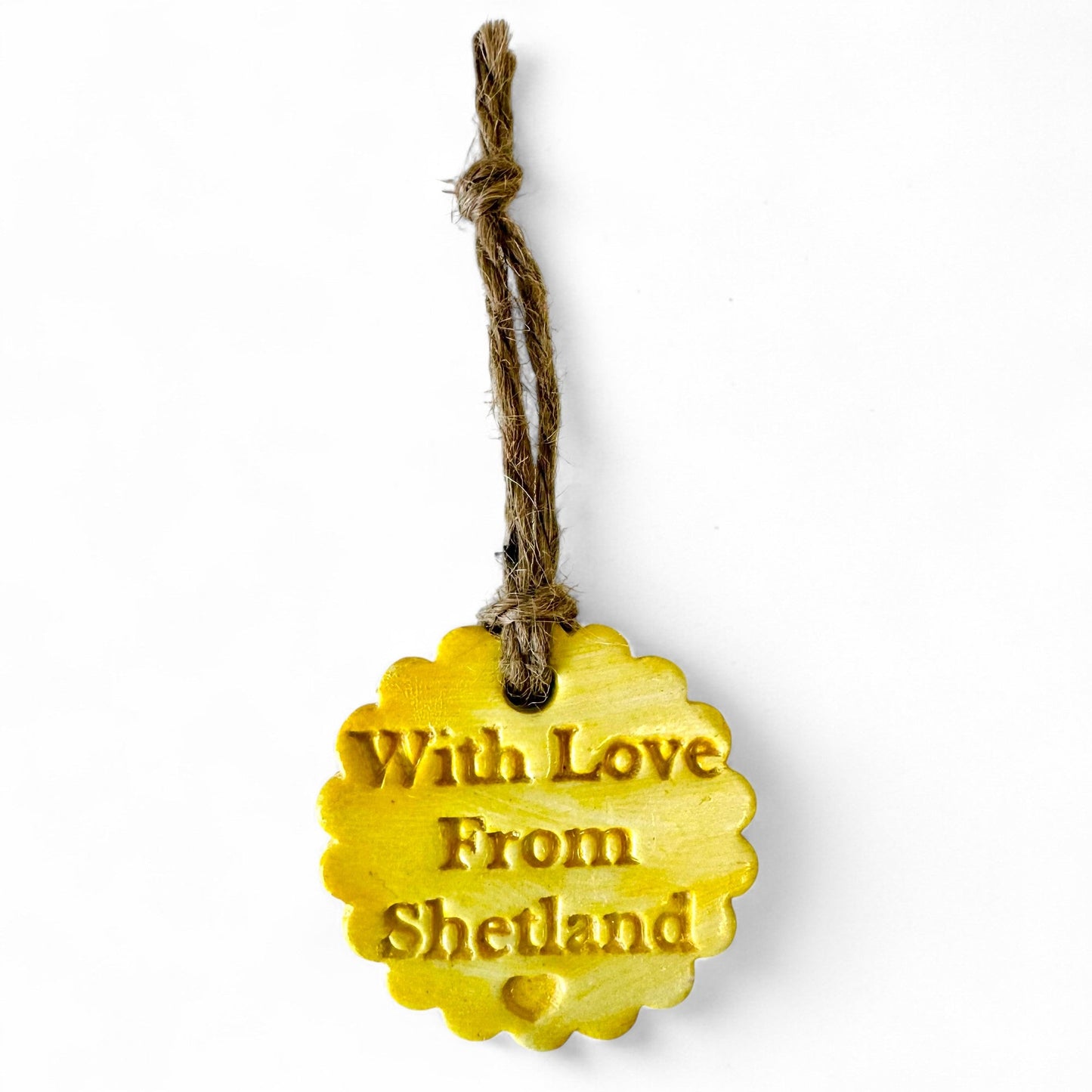 Yellow scalloped tag with "With Love From Shetland" embossed and a small heart.