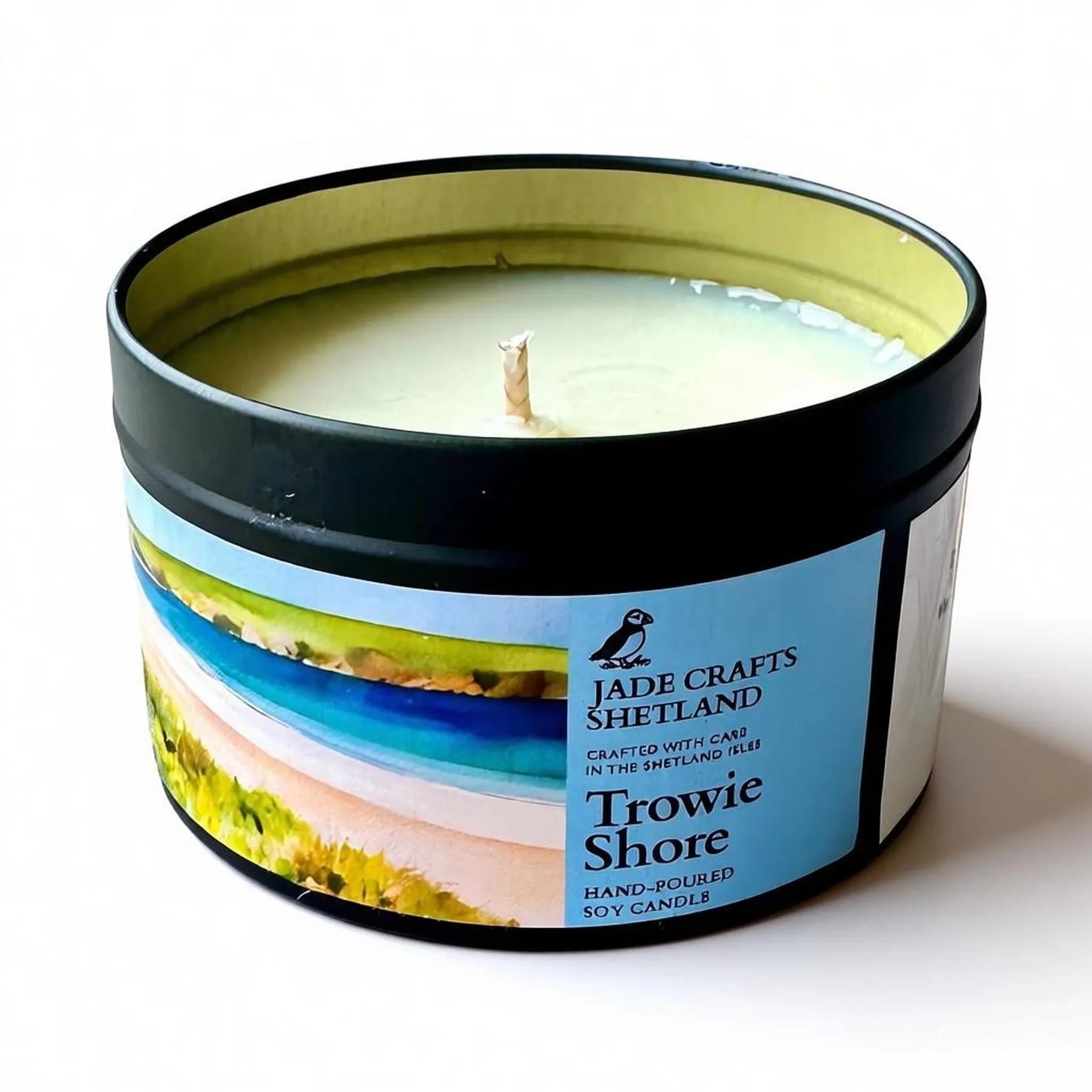 Trowie Shore hand-poured soy candle in a black tin with a coastal landscape label.
