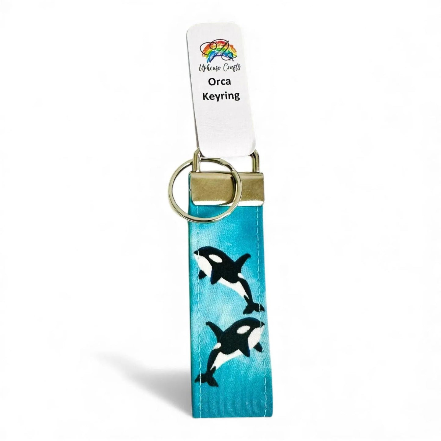 Fabric keyring featuring two orcas on a blue background with a silver metal clasp and ring.