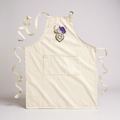 Highland Coo embroidered cotton apron with a floral crown design and a front pocket.