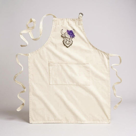 Highland Coo embroidered cotton apron with a floral crown design and a front pocket.