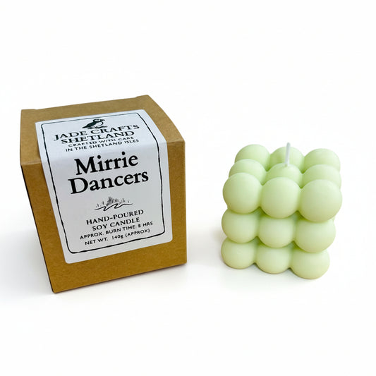 A light green bubble candle next to its brown cardboard box with a label.