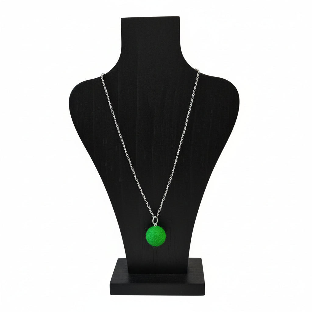 Hand felted green wool ball pendant on a silver plated chain displayed on a black bust.
