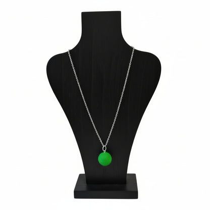 Hand felted green wool ball pendant on a silver plated chain displayed on a black bust.