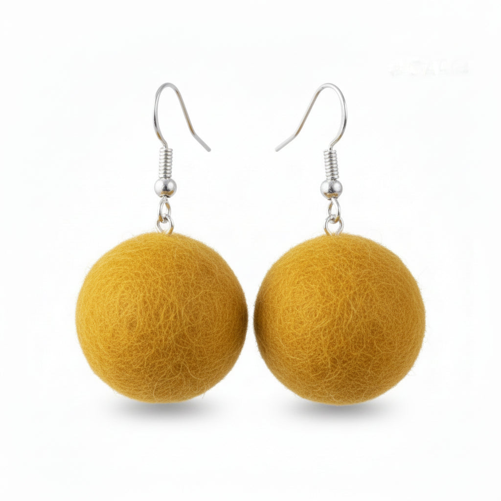 A pair of mustard yellow hand-felted wool ball earrings hanging from silver-colored hooks.