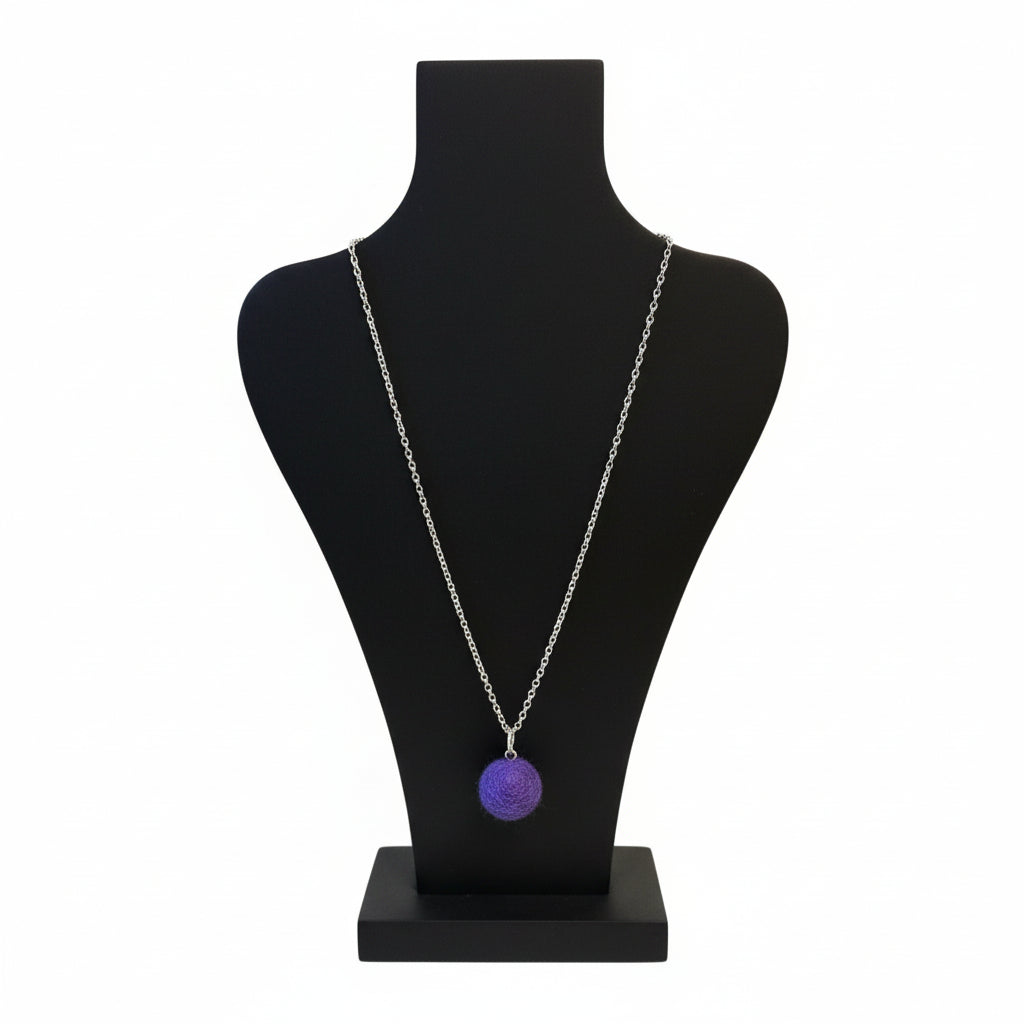 Hand felted purple wool ball pendant on a silver plated chain displayed on a black bust.