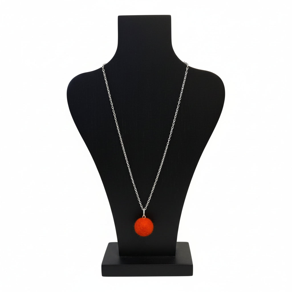 Hand felted orange wool ball necklace on a silver plated chain displayed on a black bust.