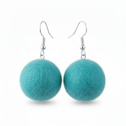 A pair of teal, hand-felted wool ball earrings with silver-colored metal hooks.