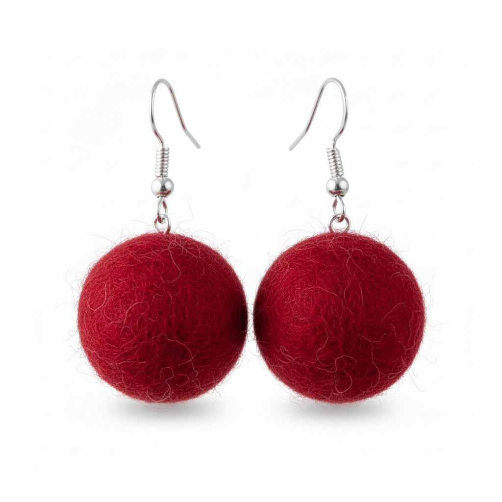 A pair of red, spherical hand-felted wool earrings with silver-colored fishhook ear wires.