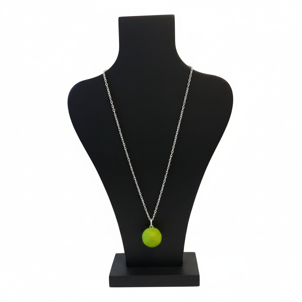 Hand felted lime green wool ball pendant on a silver plated chain displayed on a black bust.