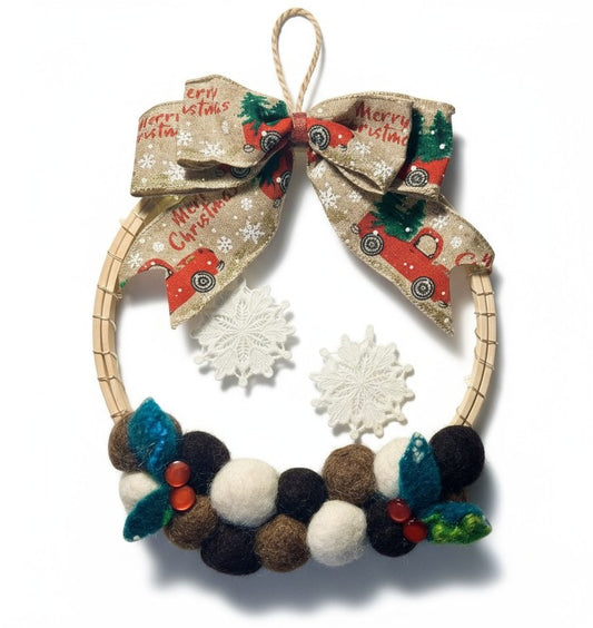 Handmade felt Christmas wreath with truck and snowflake details.